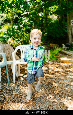 Straight on portrait of a young boy running and playing Stock Photo