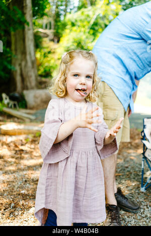 Straight on portrait of a young girl with marshmallow on her face Stock Photo