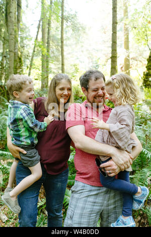 Closeup portrait of a family laughing together on a forest hike Stock Photo