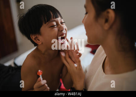 Asian boy and sister laughing in a room Stock Photo