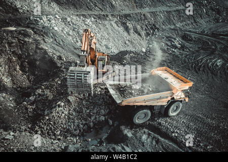 Excavator work loading of coal into Yellow mining truck. Open pit mine ...