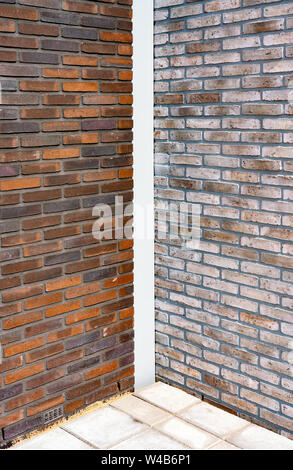 New building with dark red and beige brick surface and cobblestone on the floor Stock Photo