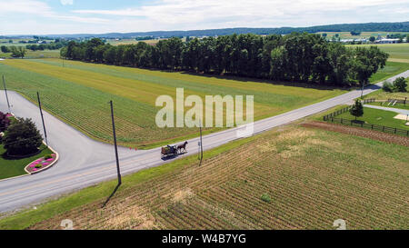 Aerial View of Amish Farm Land and a Horse and Buggy Going Down the Road