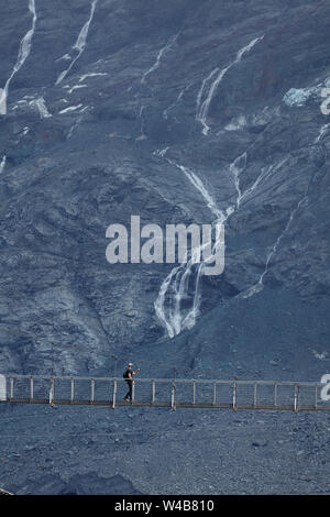 Hiker on Hooker River Footbridge & Mt Sefton, Aoraki / Mt Cook National Park, Canterbury, South Island, New Zealand Stock Photo