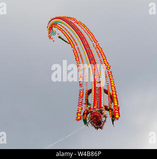 Pasir Gudang, Malaysia - March 3, 2018: Large kite train in traditional, Indonesian dragon style flying at the Pasir Gudang World Kite Festival in the Stock Photo