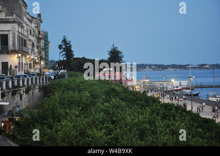 The waterfront comes alive at dusk as lights come on in Ortigia, Siracusa, Sicily. Stock Photo