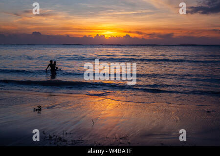 Playing in the surf at sunset, Agana Bay, Guam Stock Photo