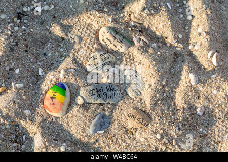 Found rocks on a beach with words and sayings written on them Stock Photo