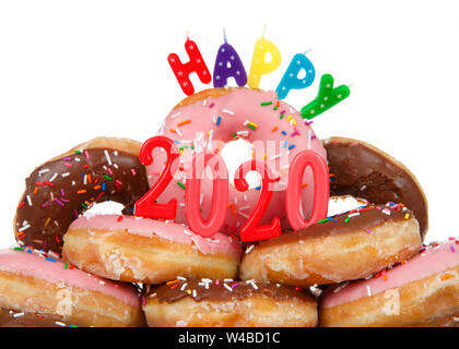 Variety of glazed donuts stacked with Happy 2020 candles, isolated on white. Happy New Year theme. Stock Photo