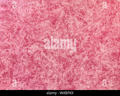 Texture of light red wallpaper with a stripped pattern. Pink paper surface, structure close-up. Decorative plaster backdrop. Stock Photo