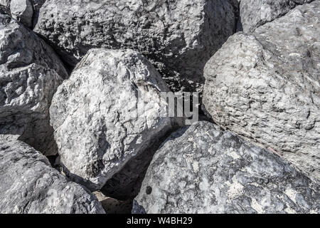 Huge gray boulders lie on the beach. Stock Photo