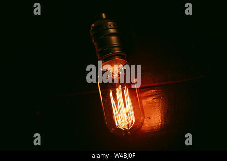 Vintage incandescent Edison type bulbs on wooden wall. Stock Photo