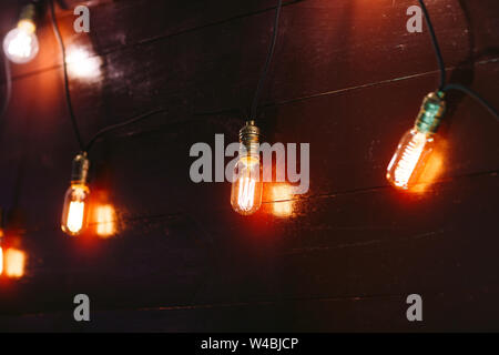 Vintage incandescent Edison type bulbs on wooden wall Stock Photo