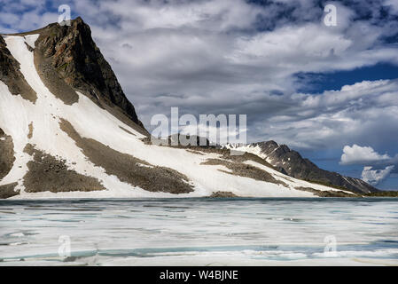 Glacier on mountain and lake with floating ice on surface. Eastern Sayan. Tuva. Central Asia Stock Photo