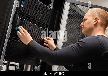 Focused Male Technician Working With Servers In Datacenter Stock Photo