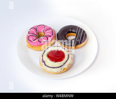 Three sweet donuts on plate on white background Stock Photo