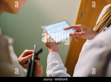 Doctors discussing patient's cardiogram on the tablet Stock Photo