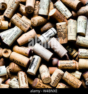 Used wine corks on sackcloth background with empty space for text. Colorful corks from white and red wine bottles Stock Photo