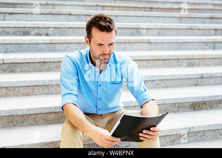 Portrait of a concentrated young man reading contract Stock Photo