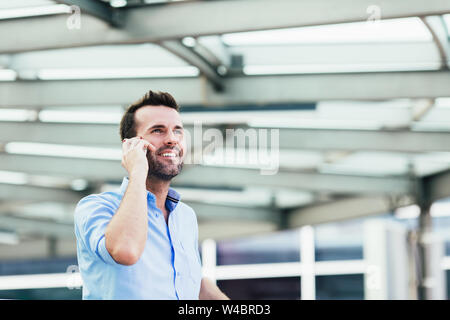Young businessman talking on phone outside the office Stock Photo