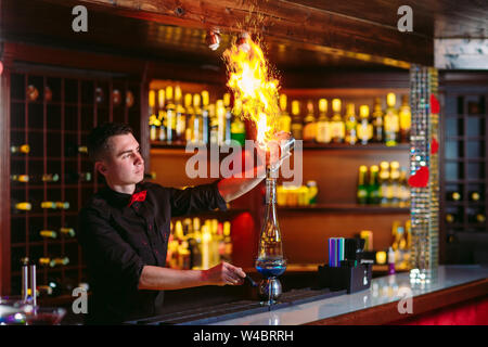 Bartender makes hot cocktail in a restaurant in the bar. Stock Photo