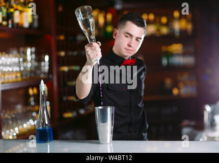 Barman pouring fresh cocktail from shaker into the glass on the bar counter  Stock Photo by ©ufabizphoto 391804472