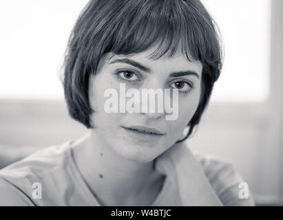 Beautiful Girl With Bob Haircut Sitting Pensively At A Cafe Stock