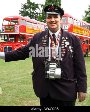 Traditional bus conductor posing with a collection of pin badges.