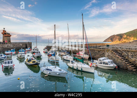 A summers evening in the picturesque little North Devon coastal village of Lynmouth as the little boats in the harbour rise up on the incoming tide. Stock Photo