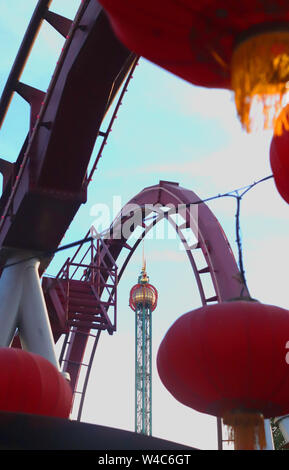 The Demon roller coaster in Tivoli Gardens, Copenhagen. In the background the Star Flyer ride. Stock Photo