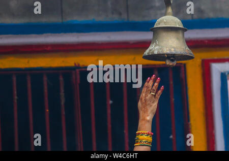 Kathmandu, Nepal. 22nd July, 2019. A hand of a woman seen trying to reach a bell hanging at the Shiva temple during a Shrawan Sombar festival.Shrawan month is considered as the holiest month of the year and each Somvar (Monday) of this month is known as Shrawan Somvar, during which devotees fast and worship Lord Shiva to pray for happiness for their families. Credit: SOPA Images Limited/Alamy Live News Stock Photo
