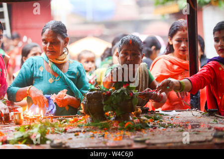 Kathmandu, Nepal. 22nd July, 2019. Devotees perform rituals at the Shiva temple during a Shrawan Sombar festival.Shrawan month is considered as the holiest month of the year and each Somvar (Monday) of this month is known as Shrawan Somvar, during which devotees fast and worship Lord Shiva to pray for happiness for their families. Credit: SOPA Images Limited/Alamy Live News Stock Photo