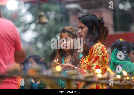 Kathmandu, Nepal. 22nd July, 2019. Devotees offer prayers by lighting a lamp for the Hindu god Lord Shiva, the god of destruction and creation, at the Shiva temple during a Shrawan Sombar festival.Shrawan month is considered as the holiest month of the year and each Somvar (Monday) of this month is known as Shrawan Somvar, during which devotees fast and worship Lord Shiva to pray for happiness for their families. Credit: SOPA Images Limited/Alamy Live News Stock Photo