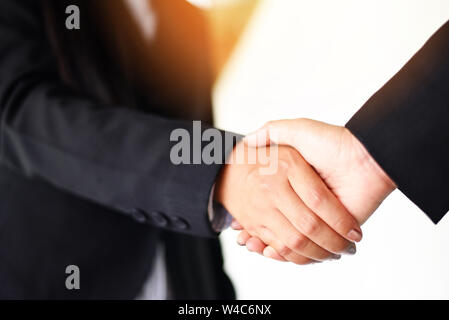 shaking hand concept / two successful asian business women shake hands people in need of exchange and cooperation finishing up meeting in a office