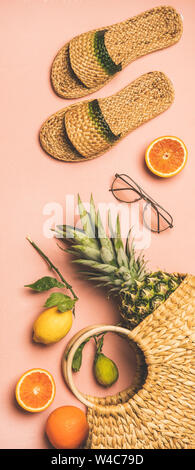 Summer apparel set and fruits over pink background, vertical composition Stock Photo