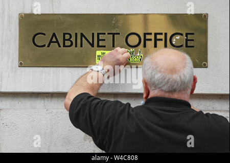 A cleaner removes anti Boris and anti Brexit stickers from the Cabinet Office in Whitehall, central London.
