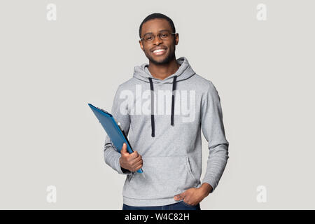 Smiling black male student stand holding binder case Stock Photo