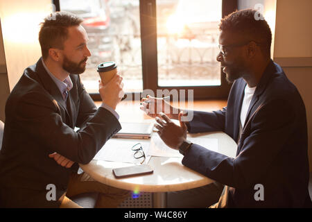 Two businessmen having a coffee break in the cafe. Stock Photo
