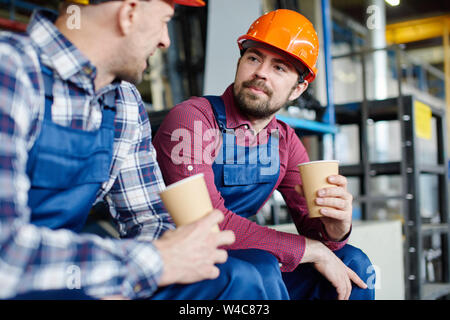 Engineers in hard hats have a coffee break. Stock Photo