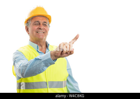 Smiling elder male builder touching invisible copyspace on display using index finger isolated on white Stock Photo