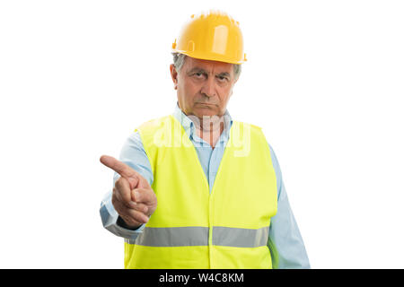 Old builder man with serious expression pointing at blank copyspace above isolated on white background Stock Photo