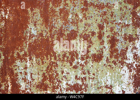 Brown rusty metal sheet with peeling black paint surface texture