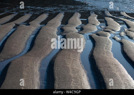 Abstract close up of ripples in the sand and water, on a beach in North Cornwall, England Stock Photo