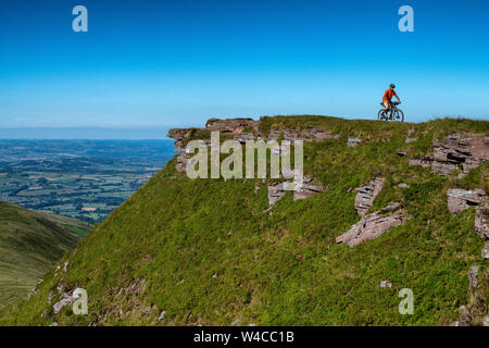 A man bike packing in the Brecon Beacons in Wales during the summer. Mountain biking Brecon Beacons. Stock Photo