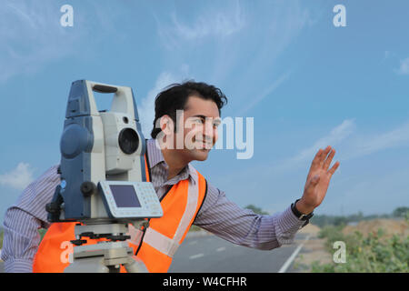 Surveyor using theodolite on tripod Stock Photo