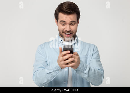 Man holding looking at smartphone feels surprised studio shot Stock Photo