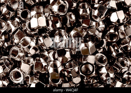 Chromed screw nuts from above. Many screw nuts. Screw nuts of different sizes. background. Stock Photo