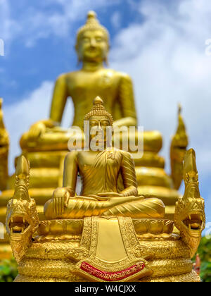 Golden Buddha statue near the huge sculpture of the Great white Buddha in Phuket. Big Buddha-one of the attractions of Phuket. Stock Photo