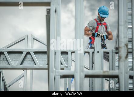 Construction Business Industry. Caucasian Skeleton Frame Worker in His 30s. Safety Harness.