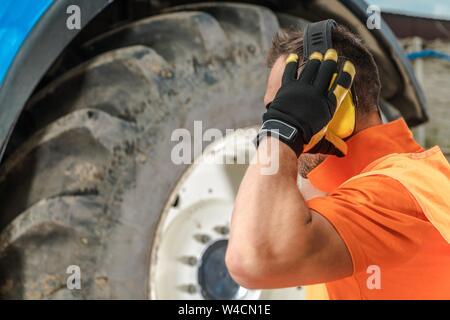 Noise Protection Equipment. Construction Heavy Equipment Operator Wearing Yellow Hard Hat. Industrial Safety Theme. Stock Photo